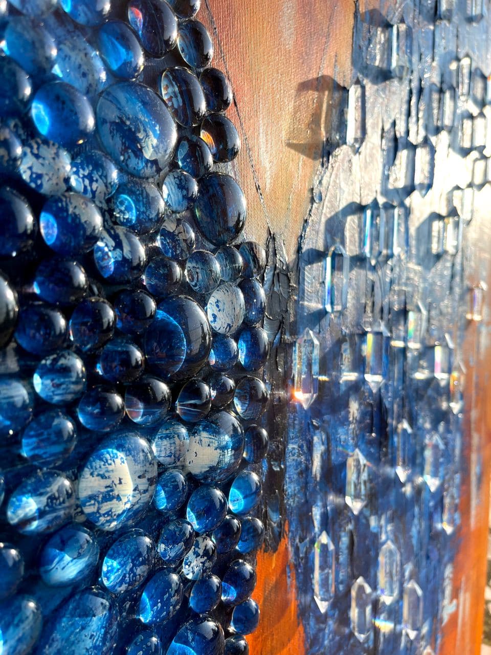 Close-up of Butterfly Matrix Cristal in low sunlight: domed clear drops over the blue left wing, cast crystals casting long shadows on the right wing.